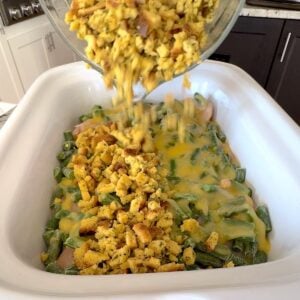 Topping the chicken casserole with stuffing.