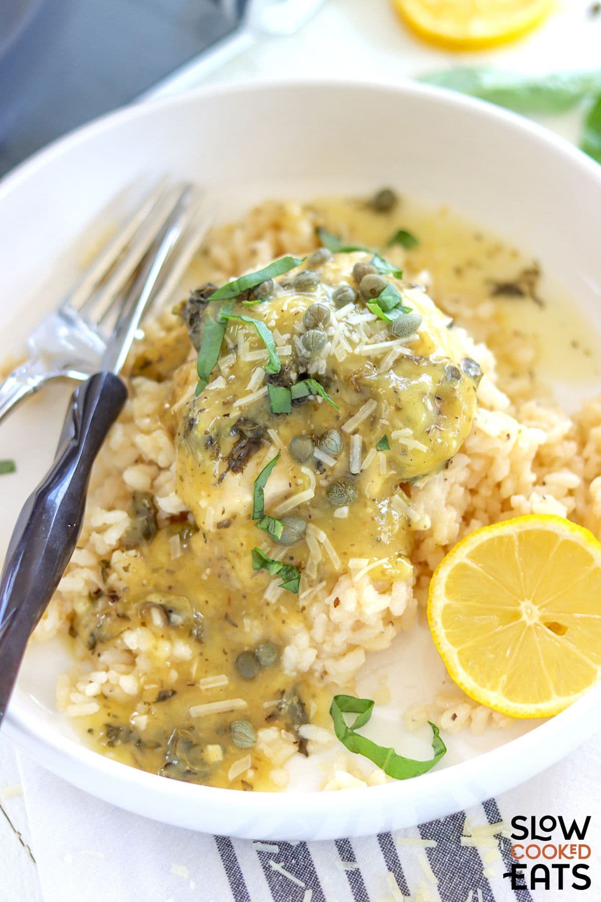 Lemon pepper chicken crockpot served over rice on a plate.