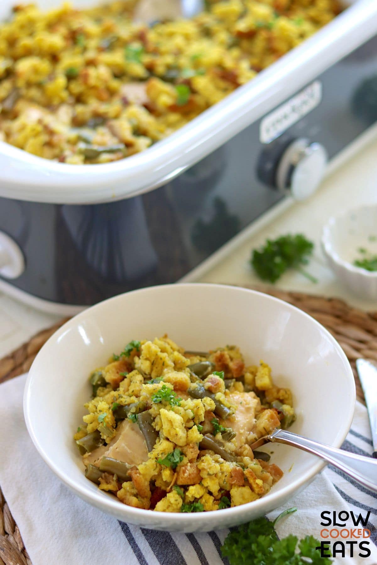 Slow cooker chicken and stuffing in a bowl with a spoon.