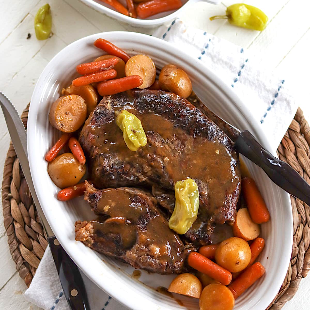 Tender beef pot roast covered in gravy with potatoes and carrots.