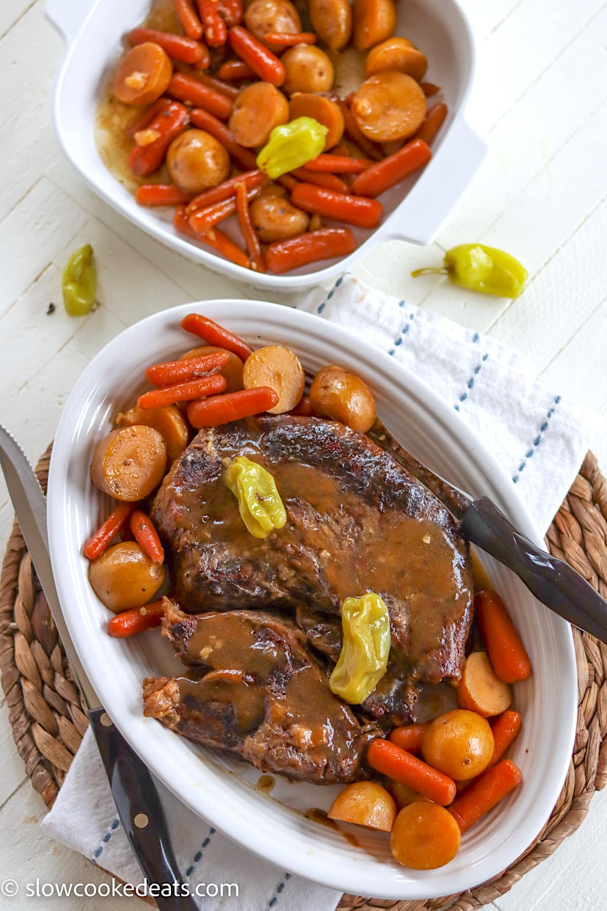 A white oval platter served with Mississippi pot roast and vegetables with gravy.
