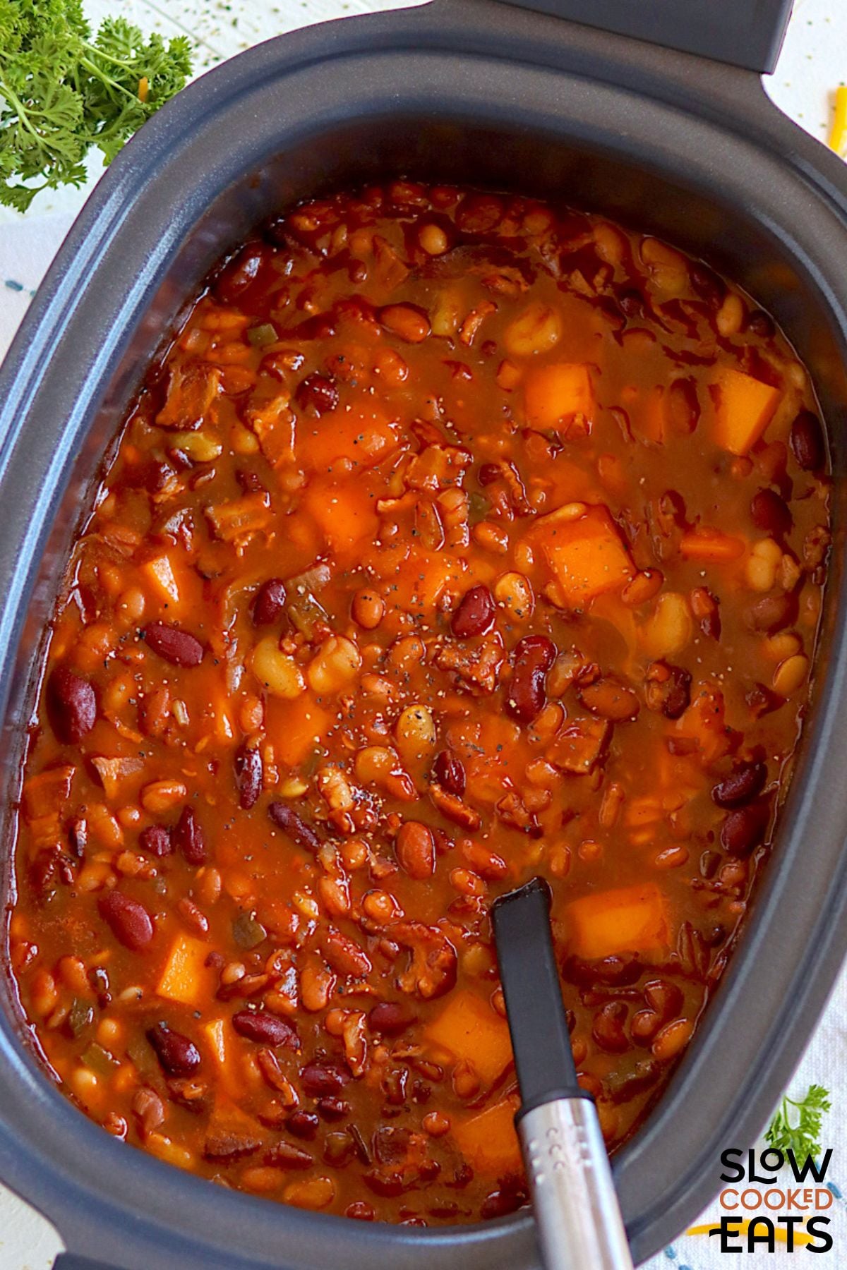 Crock pot baked beans with bacon and cheddar cheese pieces.