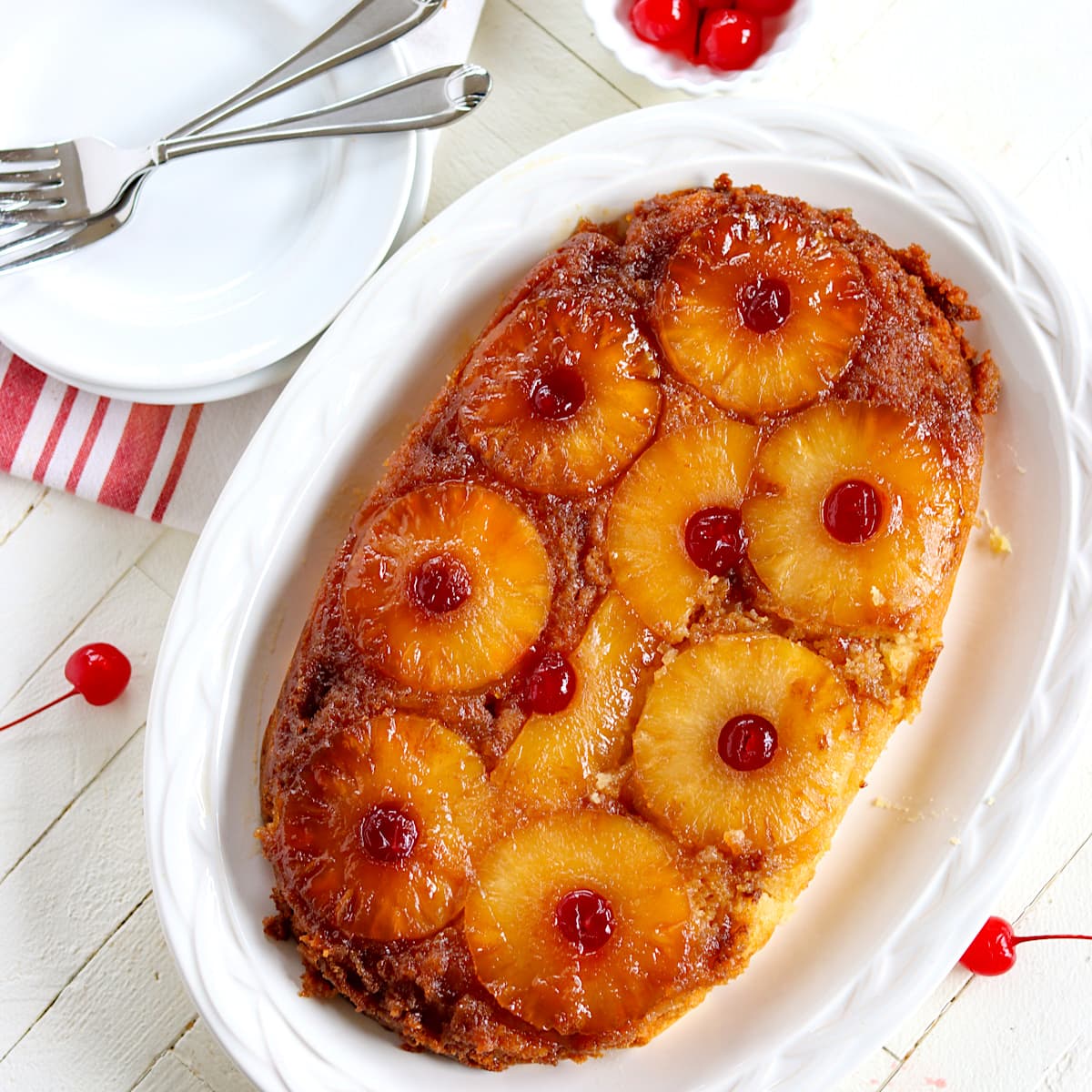 A crock pot pineapple upside down cake served on a white oval platter