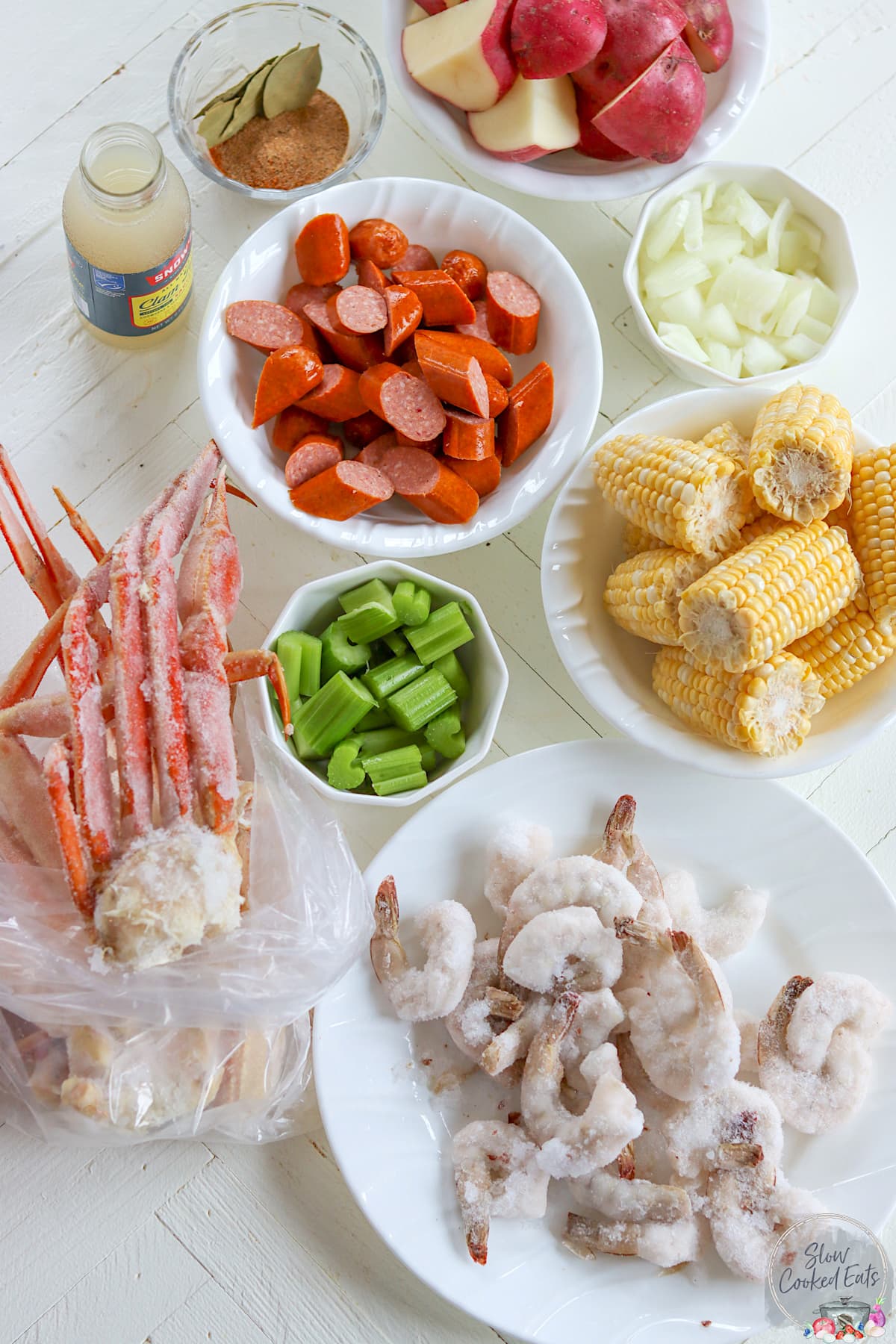 Ingredients needed for making crock pot seafood boil on a white board.