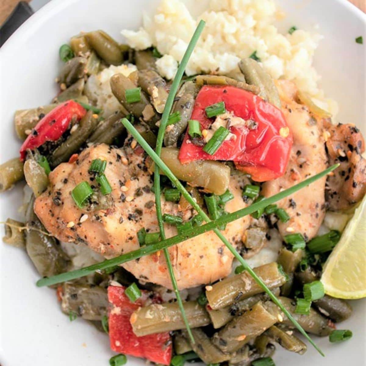 Thai chicken curry served in a white bowl with green beans.