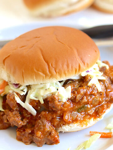 Crock pot sloppy joes served on a gray plate with coleslaw.