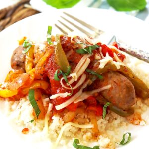 Sausage and peppers served with marinara sauce over rice.