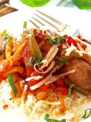 Sausage and peppers served with marinara sauce over rice.