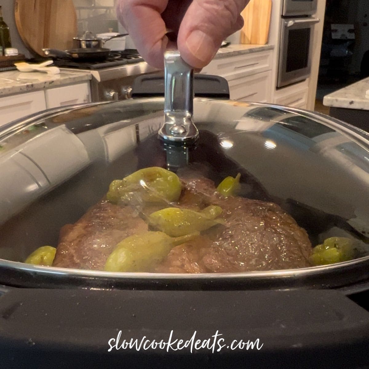 Slow cooking the pot roast in a black crock pot.