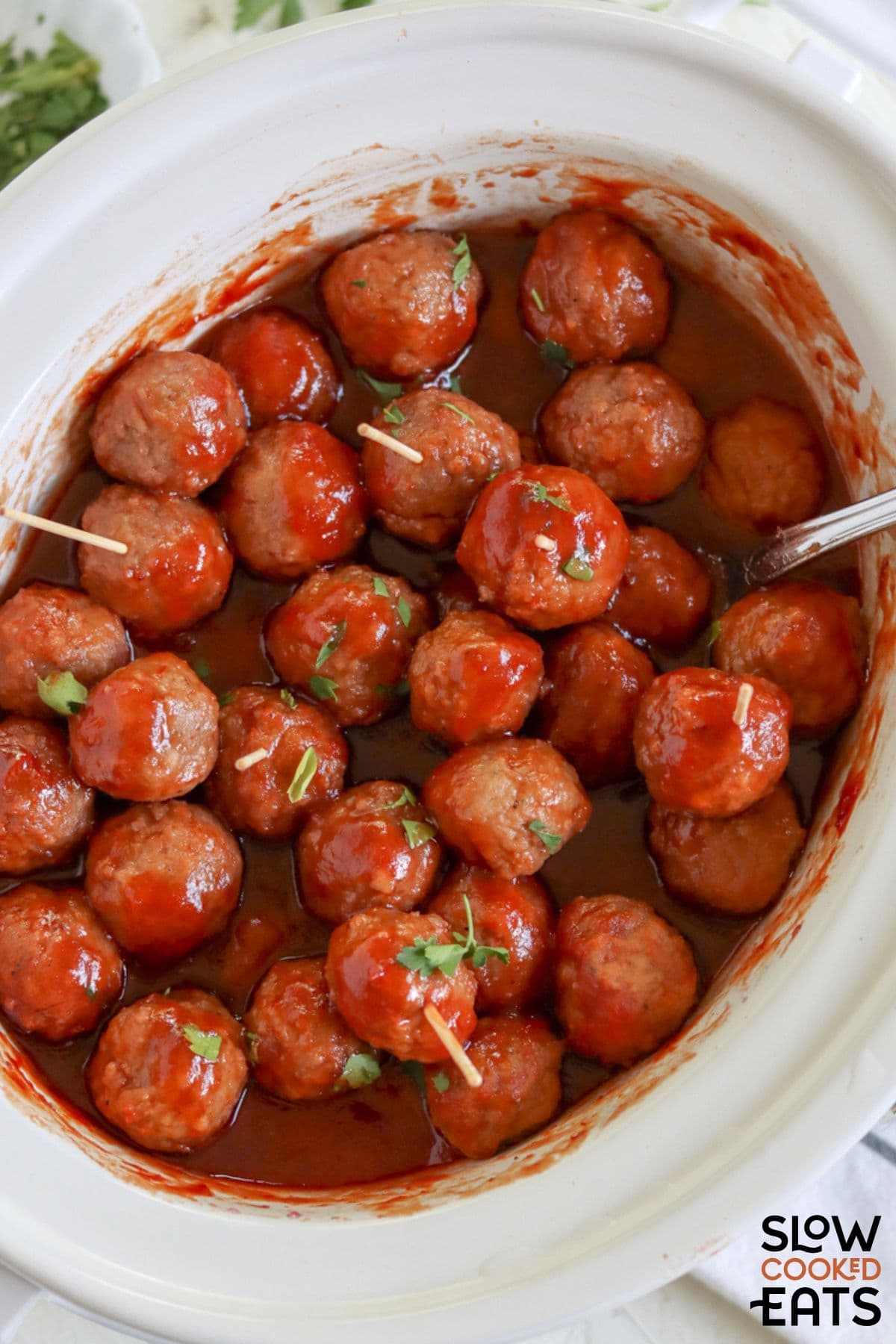 Grape jelly chili sauce meatballs crockpot style being served.