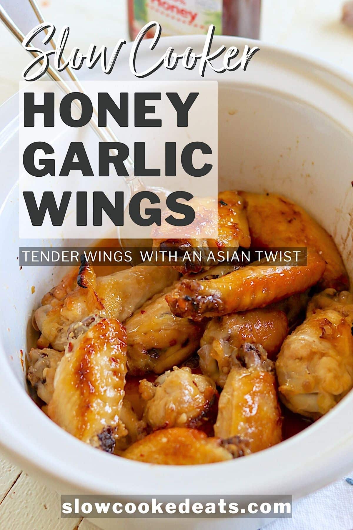 Pinterest pin with slow cooker honey garlic wings in a white oval crock pot.