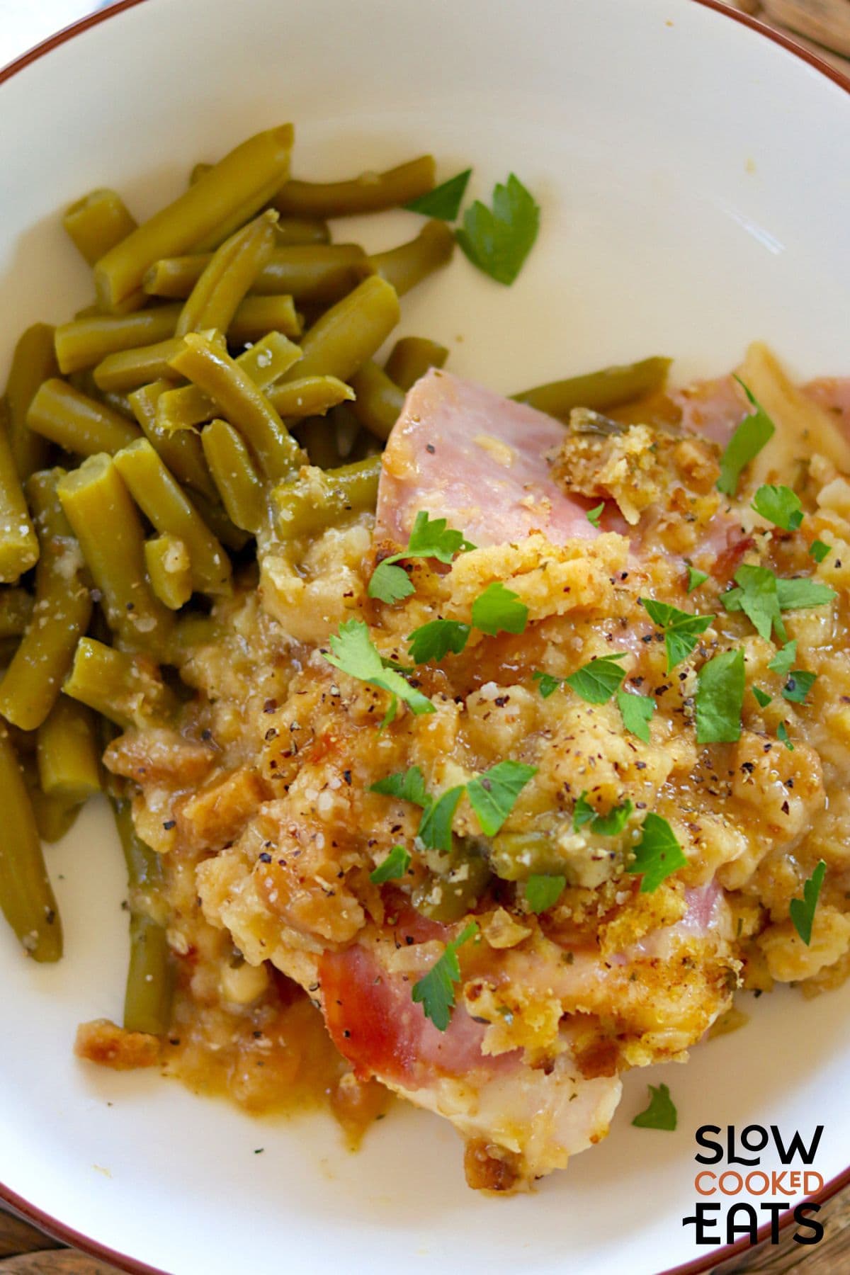 Plate of crock pot chicken cordon bleu with stuffing with green beans.