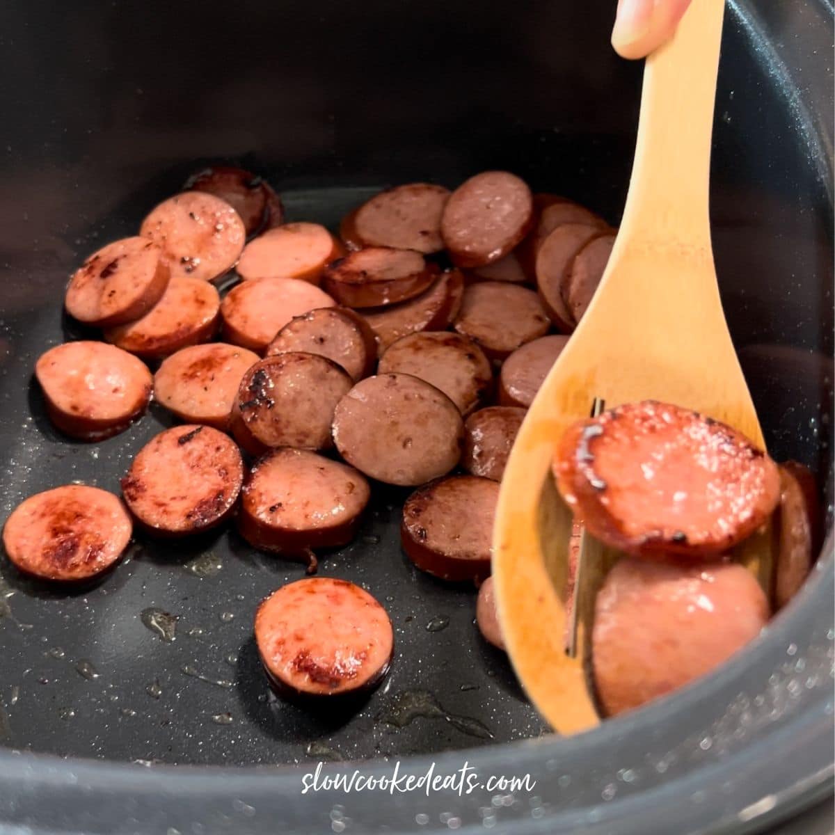 Removing the andouille sausage from the crockpot.