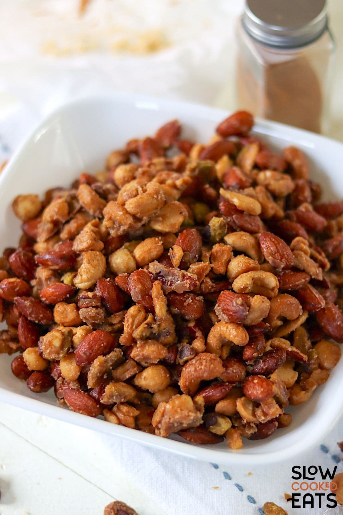 Crock pot candied nuts close-up served in a white bowl.