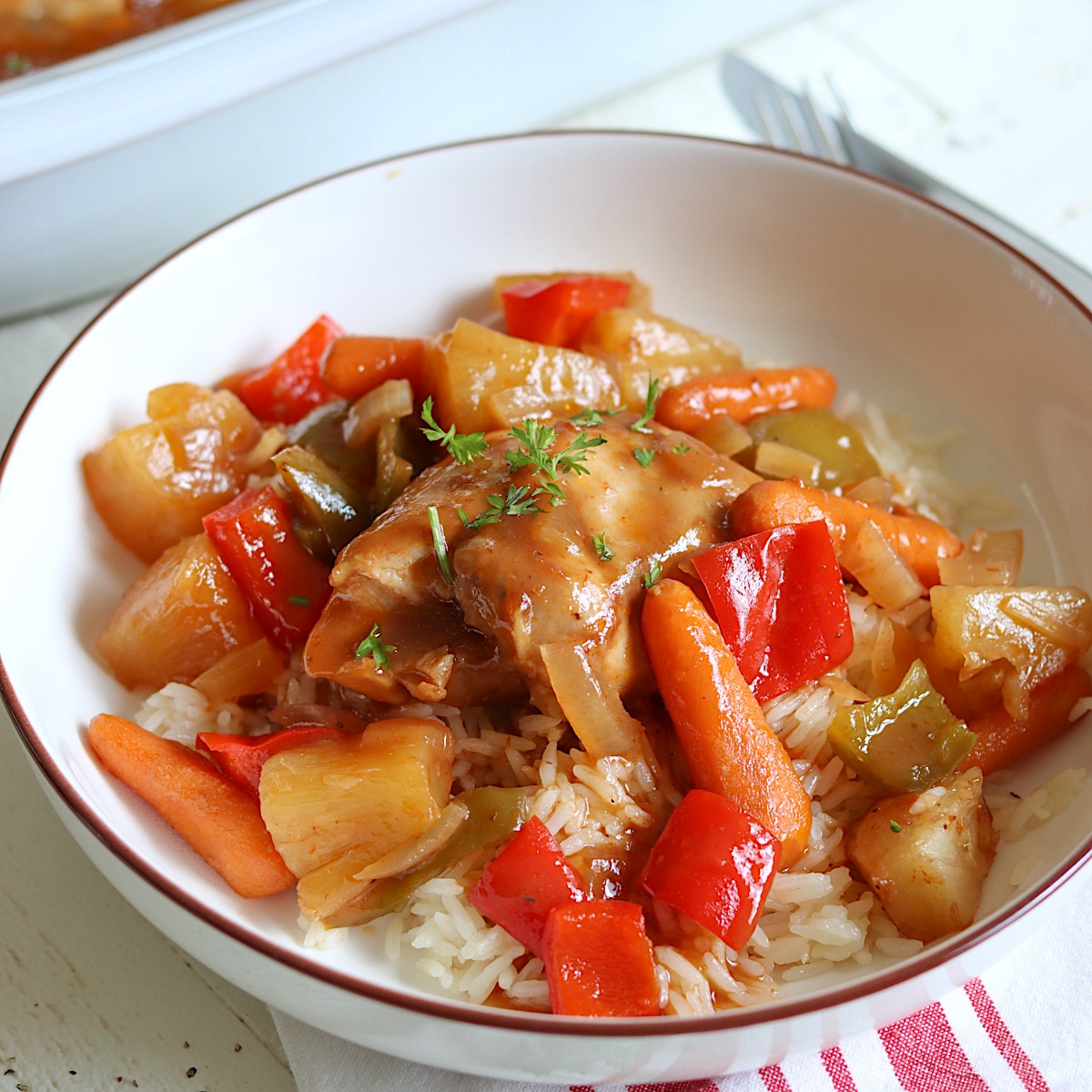 Crock pot chicken hawaiian recipe served in a white bowl over rice.