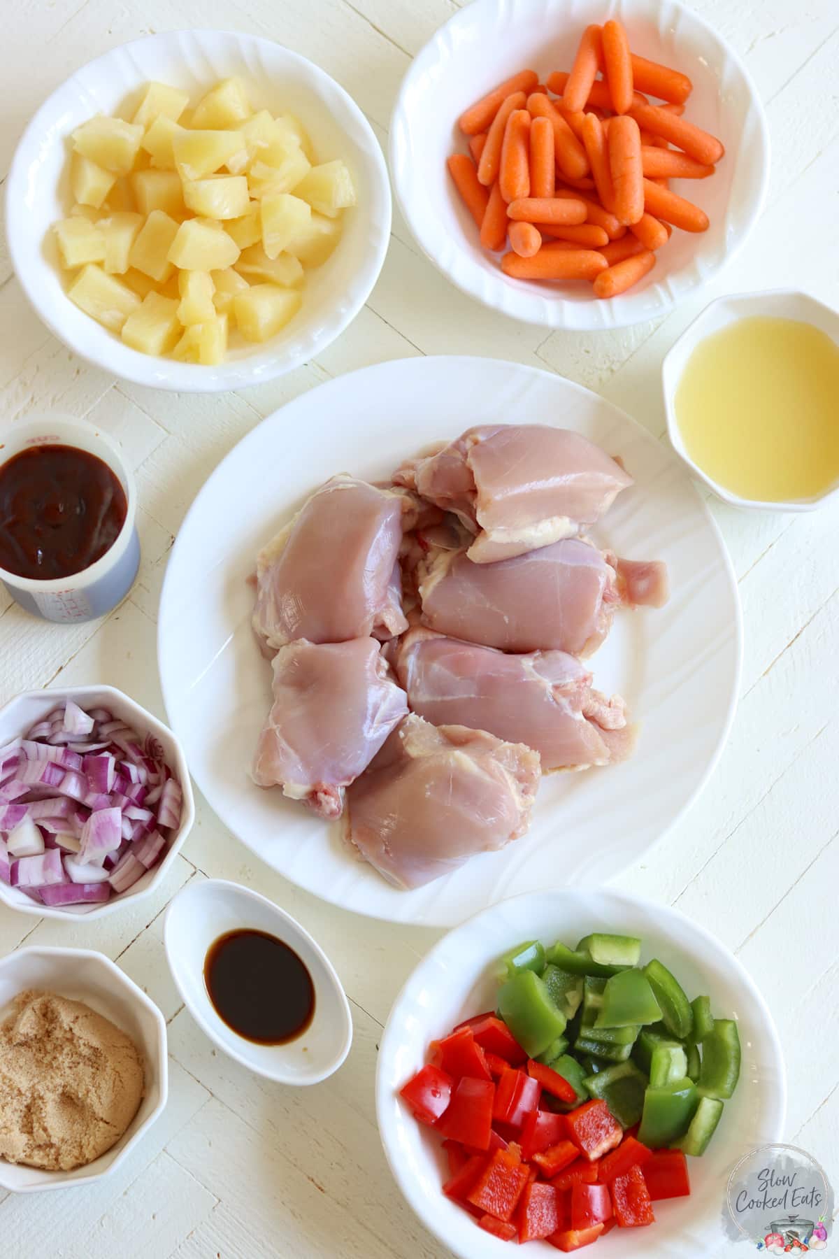 Ingredients needed for making crockpot Hawaiian chicken on a white wooden board.