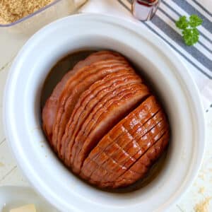 Slow cooker ham with coke in a white crockpot.