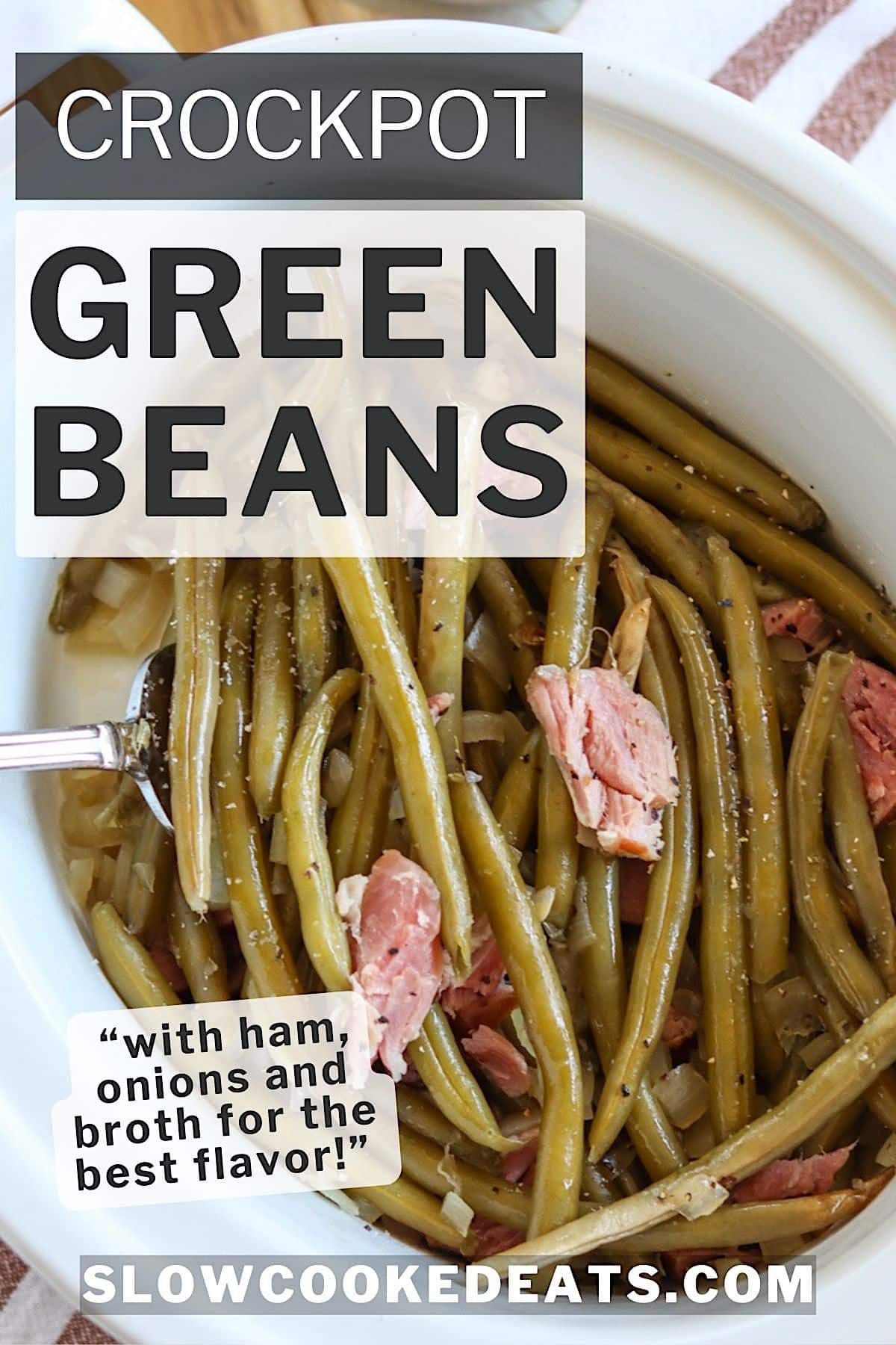 Slow cooker green beans with ham and onions in a white crock pot.