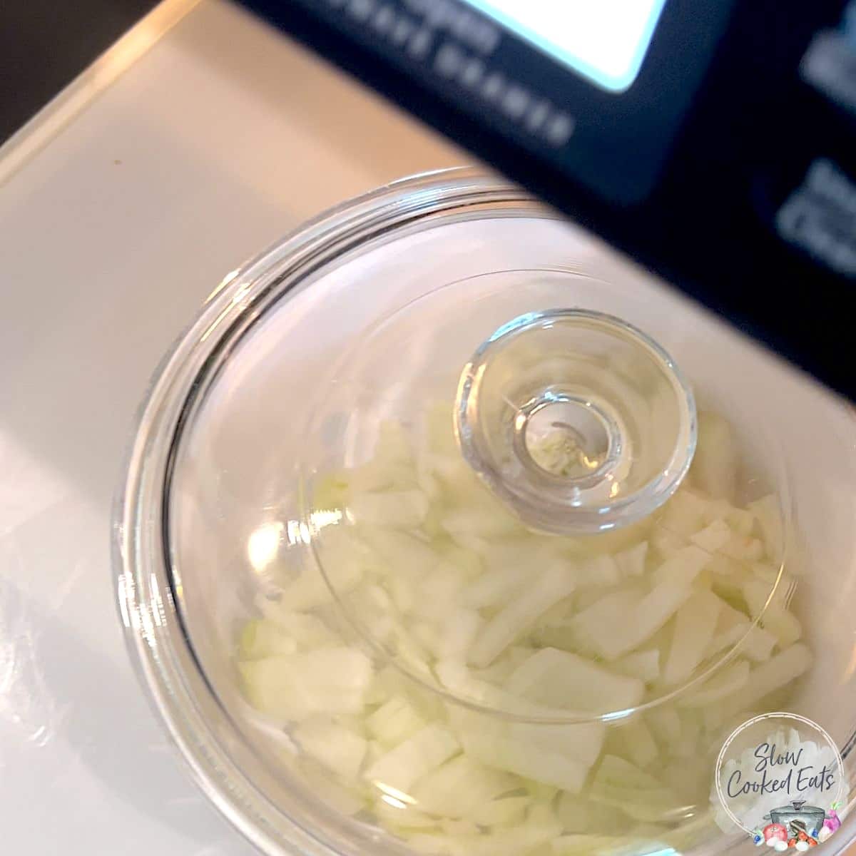 Microwaving the onion in a white lidded dish to soften.