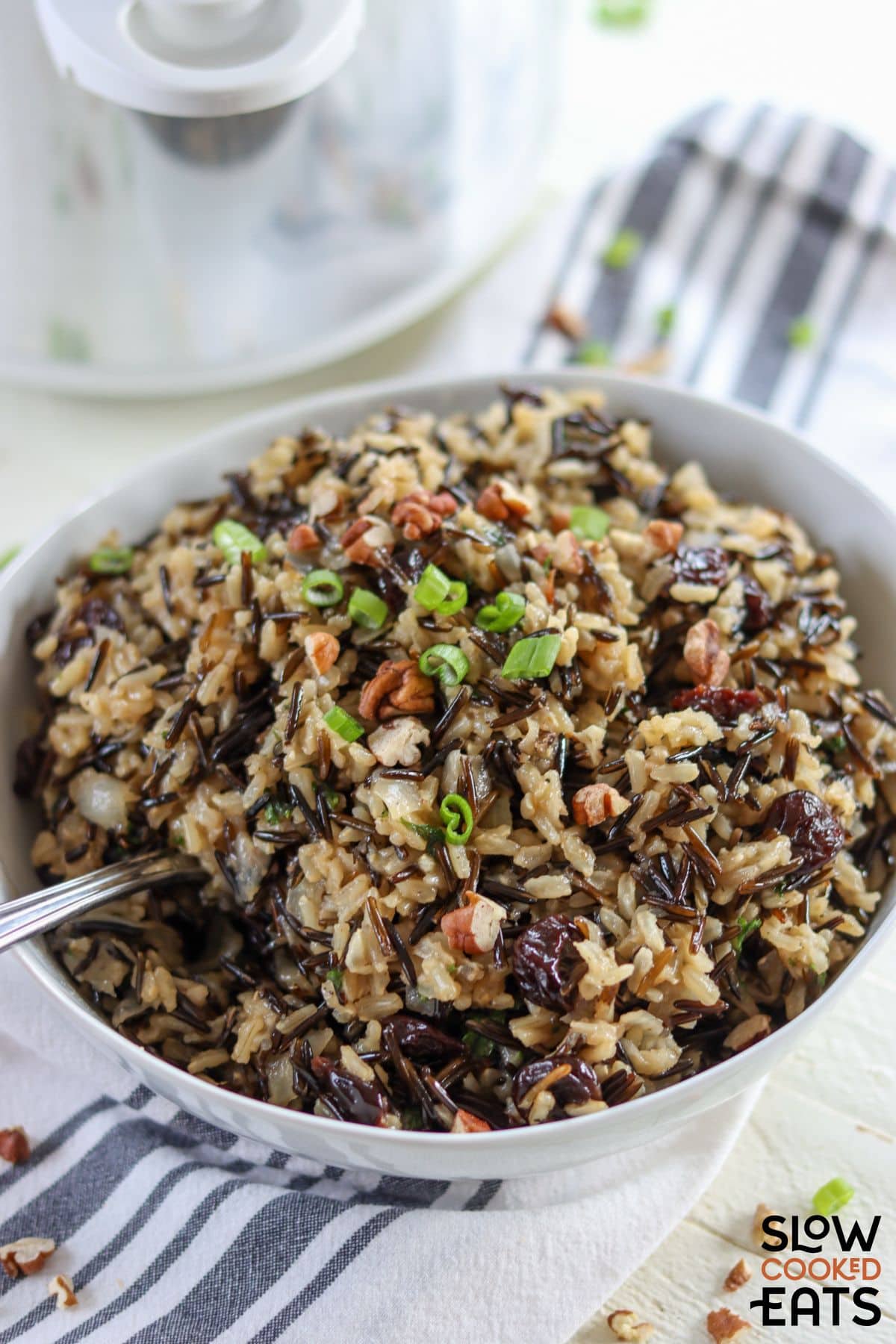Crock pot brown rice pilaf served with spoon.