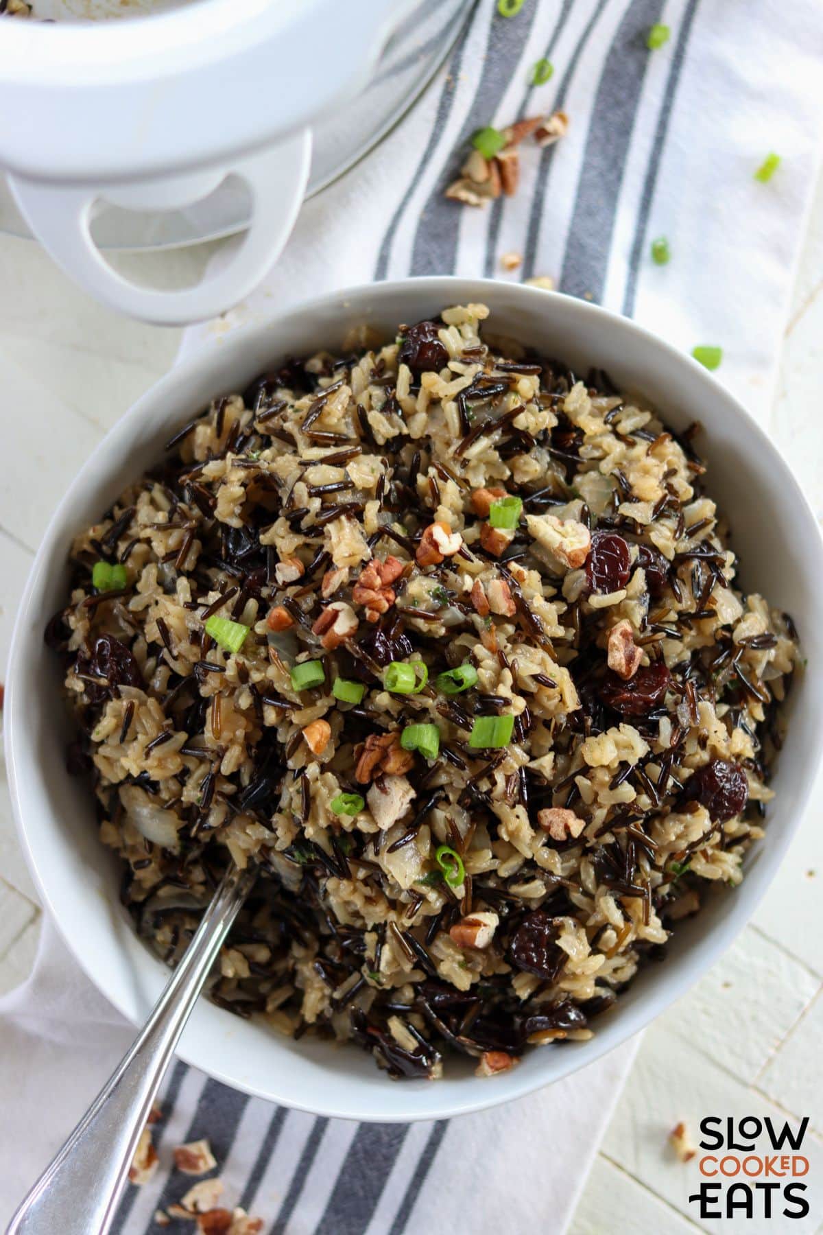 Crockpot brown rice pilaf with dried cranberries served in a bowl.