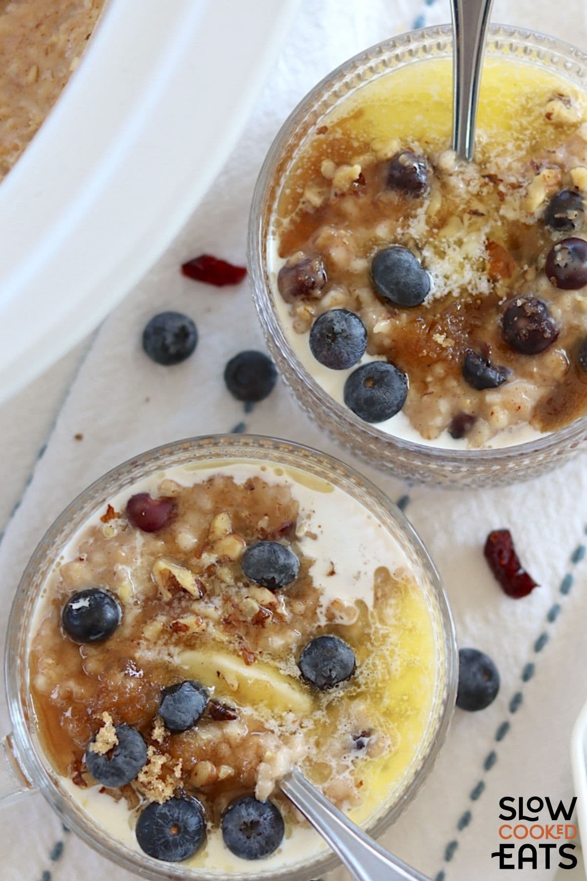 Two bowls of oatmeal with blueberries made in the slow cooker.