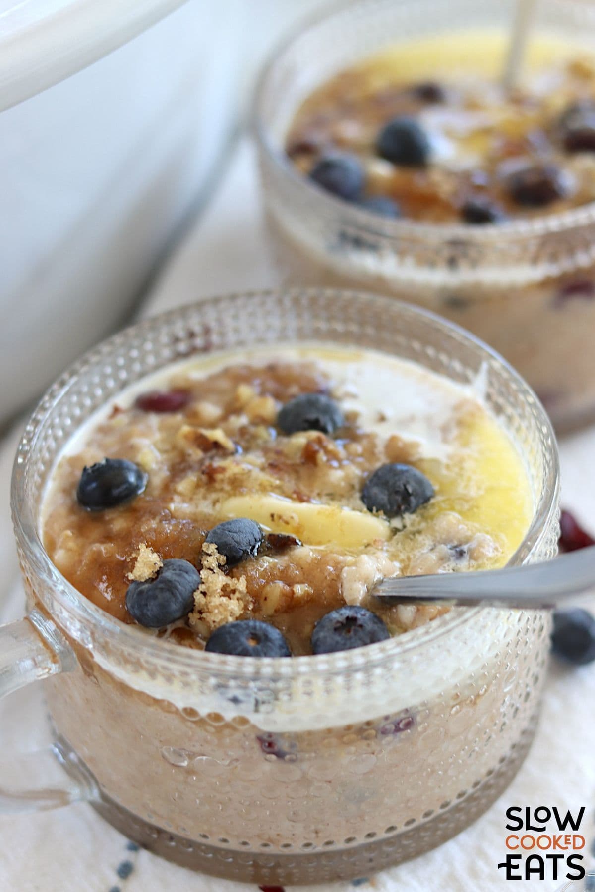 Bowl of slow cooker blueberry oats with brown sugar on top.