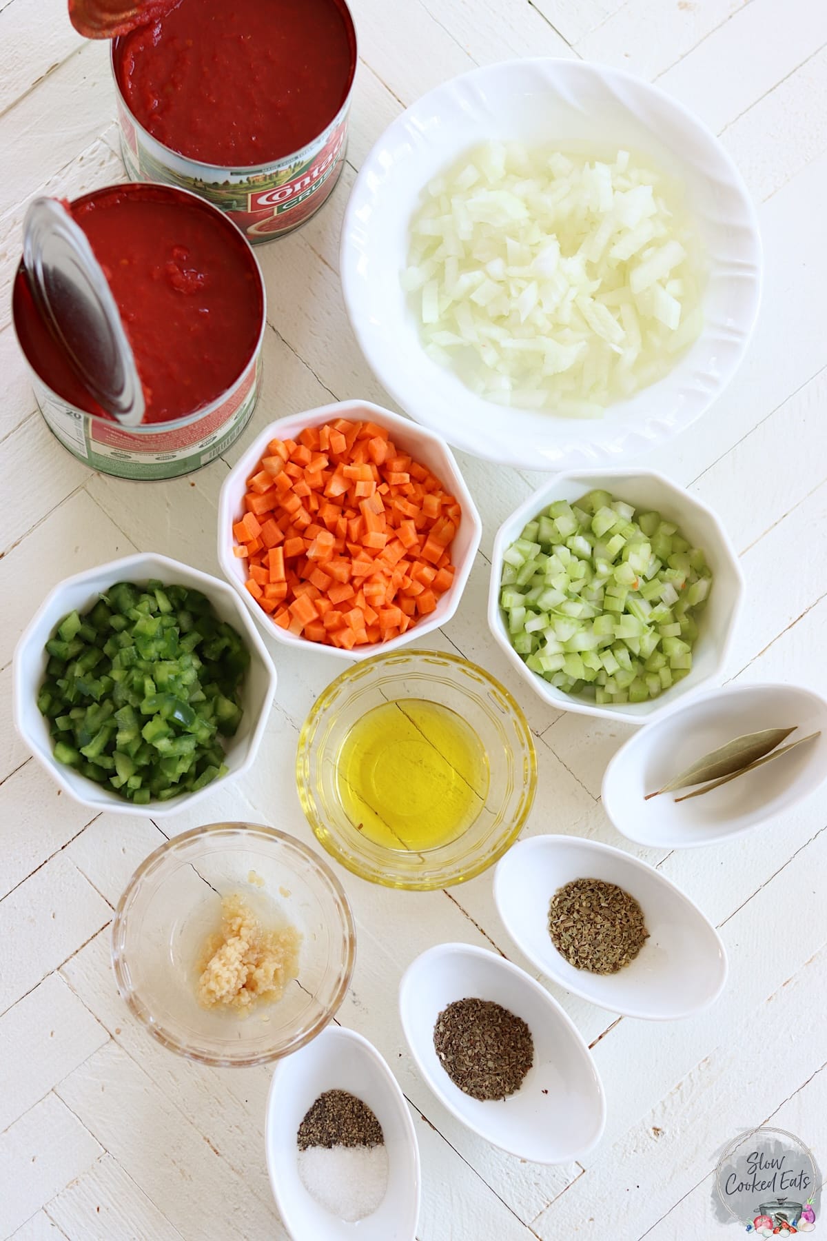 Ingredients needed for making crock pot marinara on a white wooden board.
