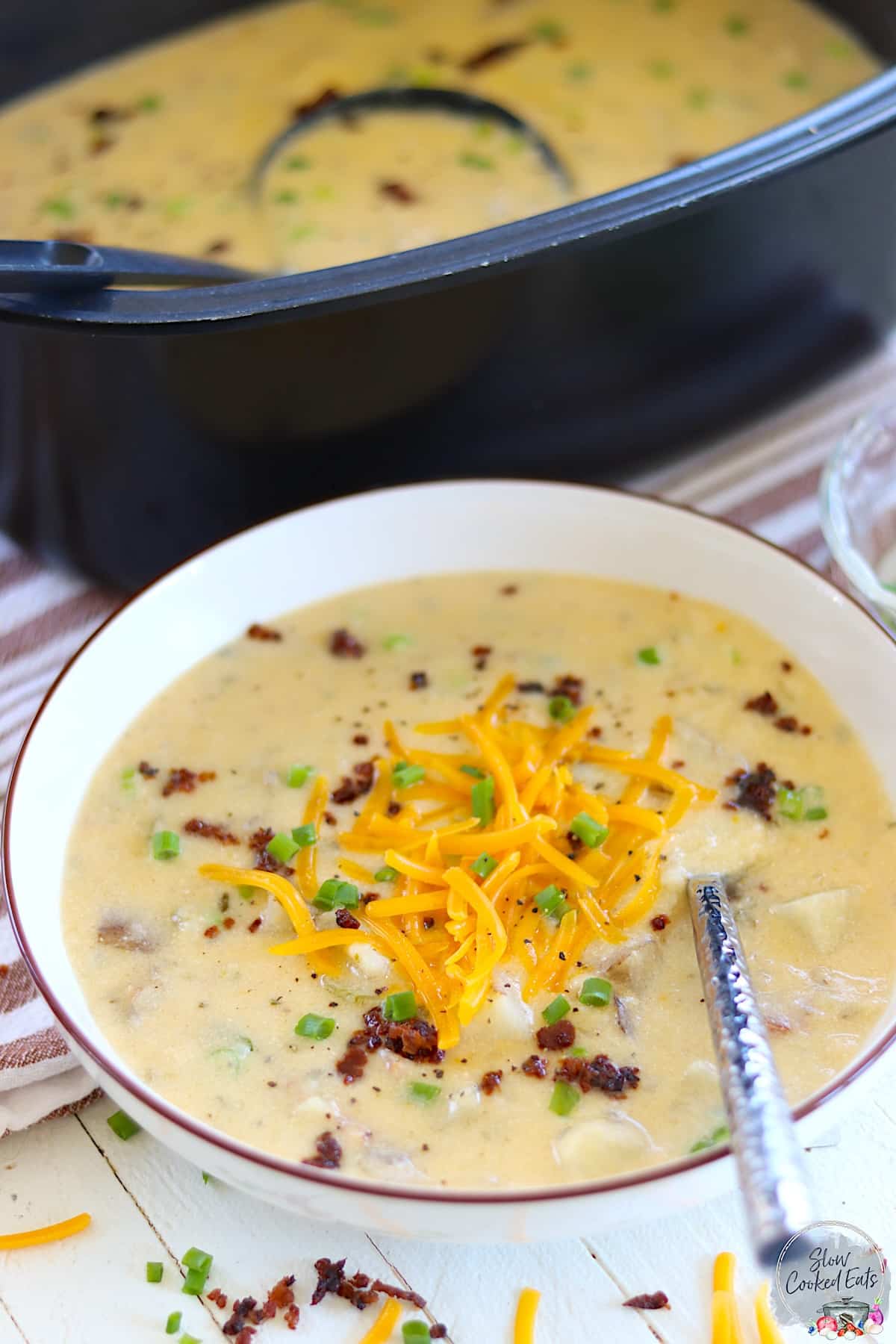 Crockpot Loaded Baked Potato Soup in a white bowl with brown rim.