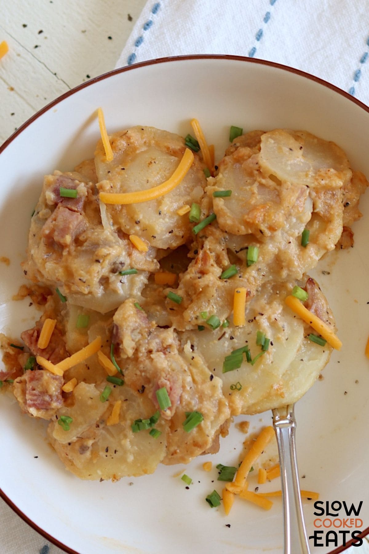 Plate of cheesy scalloped potatoes and ham.