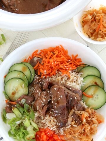 A Korean-style bbq bowl with beef, rice, and colorful vegetables.