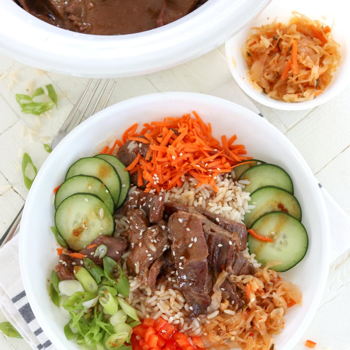 A Korean-style bbq bowl with beef, rice, and colorful vegetables.