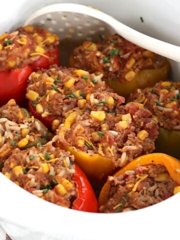 Eight stuffed peppers in a slow cooker.