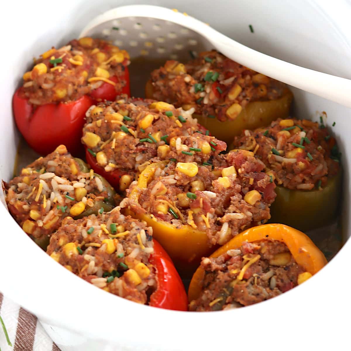 Eight stuffed peppers in a slow cooker.