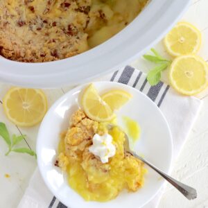 A white plate with a scoop of crockpot lemon dump cake.