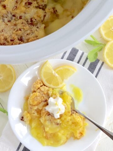 A white plate with a scoop of crockpot lemon dump cake.