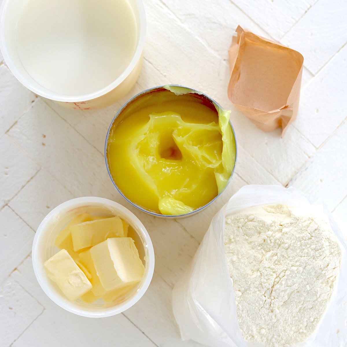 Ingredients needed for making crockpot lemon dump cake on a white wooden board.