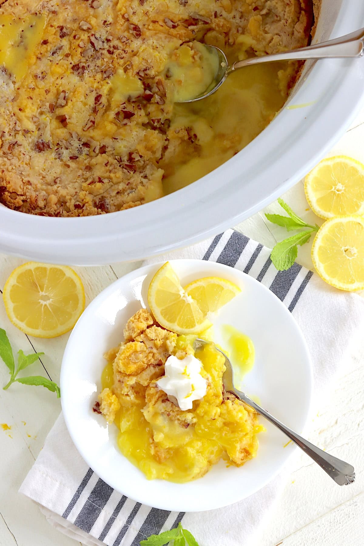A white oval crockpot with lemon dump cake.