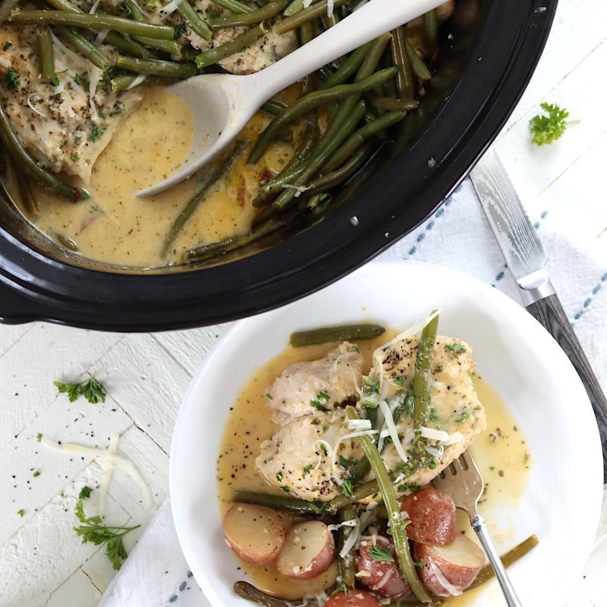 Chicken and potatoes slow cooker recipe in a black crock pot and white bowl.