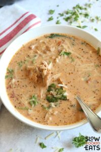 A bowl of marry me chicken soup crock pot recipe on a white board.