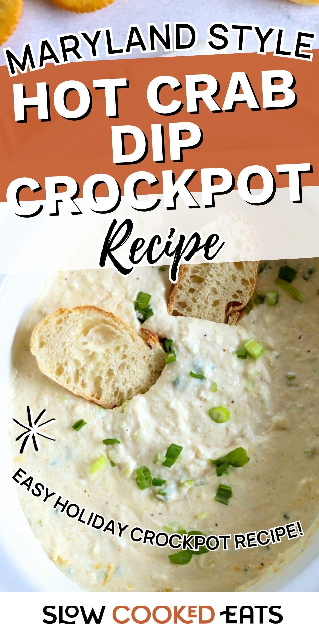 Bowl of creamy hot crab dip made in a crockpot, topped with green onions and served with slices of bread.