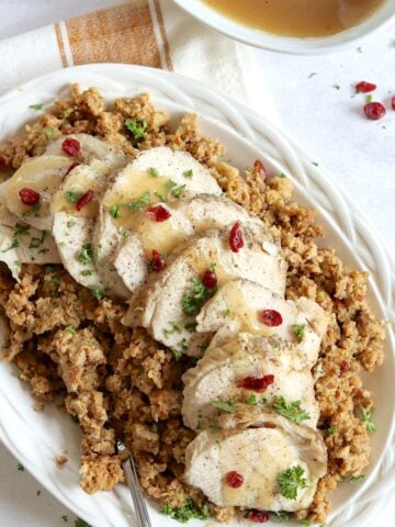 Crockpot turkey and stuffing served on a white platter and silver spoon.