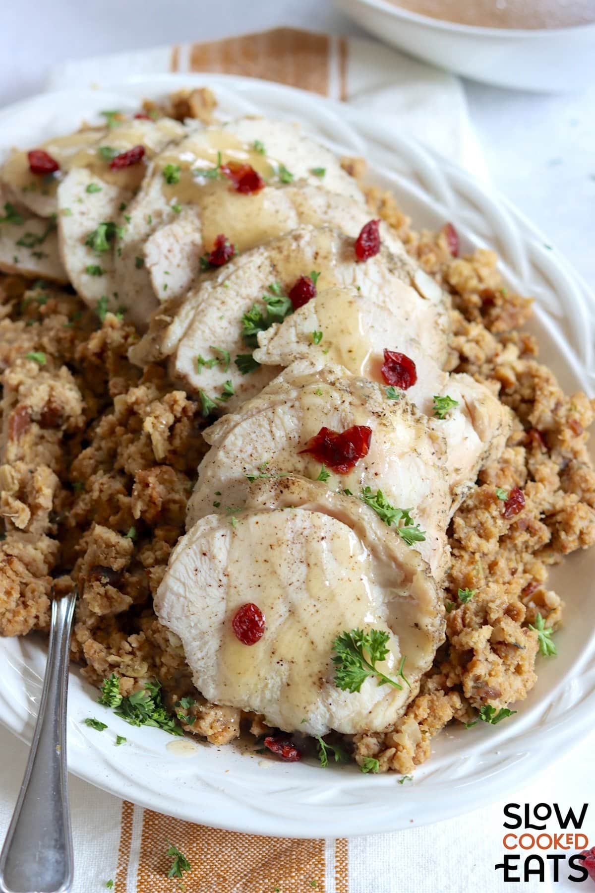 Crockpot turkey and stuffing served on a white dinner plate and silver fork.