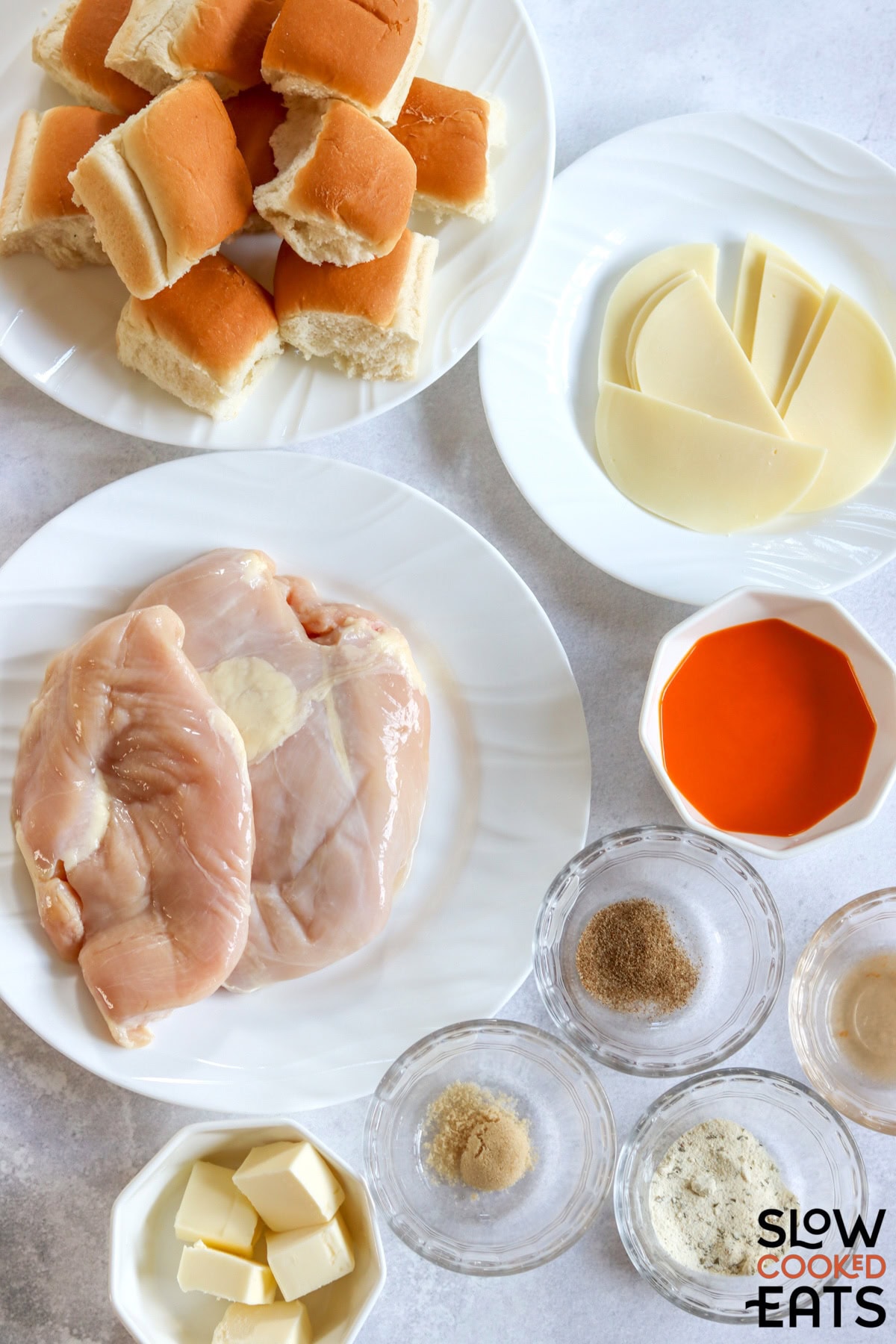 Ingredients needed for making buffalo chicken sliders slow cooker recipes on a white board.