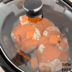 Slow cooking crockpot buffalo chicken sliders.