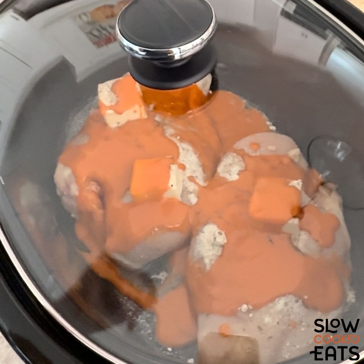 Slow cooking crockpot buffalo chicken sliders.