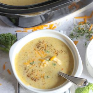 A white bowl of chicken broccoli soup slow cooker recipe.
