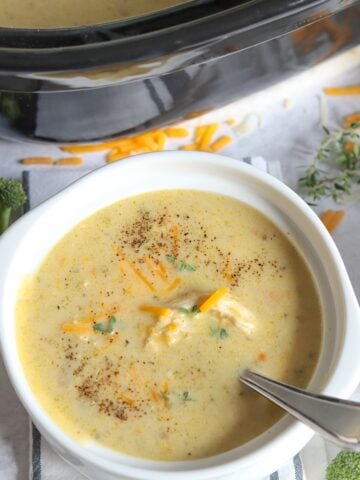 A white bowl of chicken broccoli soup slow cooker recipe.