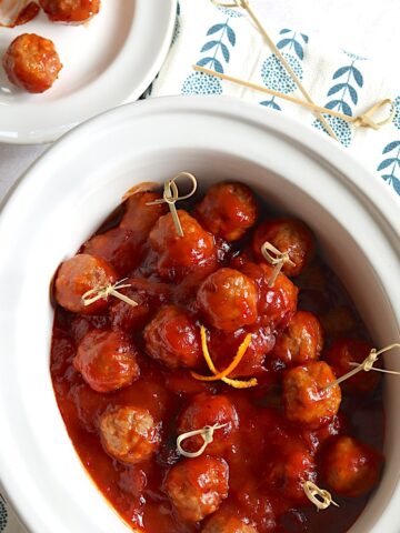 Cranberry meatballs in a crockpot with toothpicks.