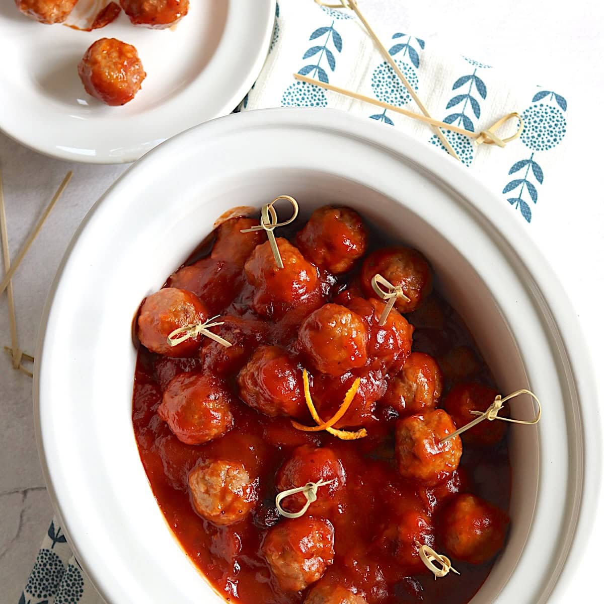 Cranberry meatballs in a crockpot with toothpicks.